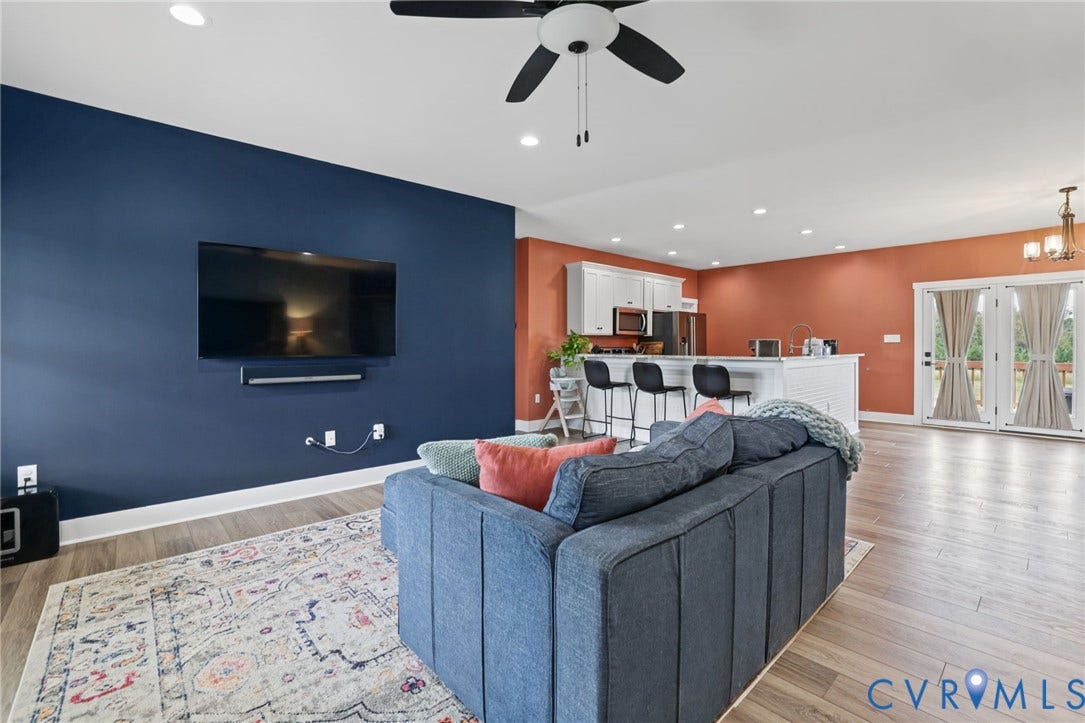 Open-concept living area featuring wood-finish flooring, recessed lighting, and a ceiling fan