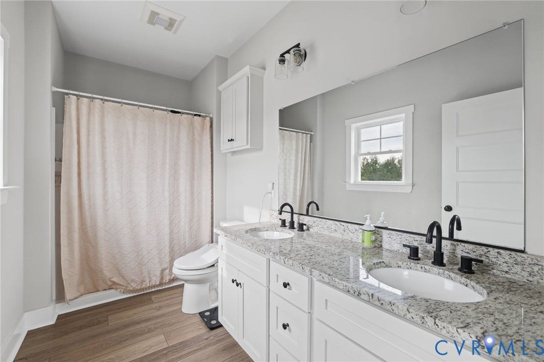 Dual vanity with granite countertop, undermount sinks, and matte black fixtures
