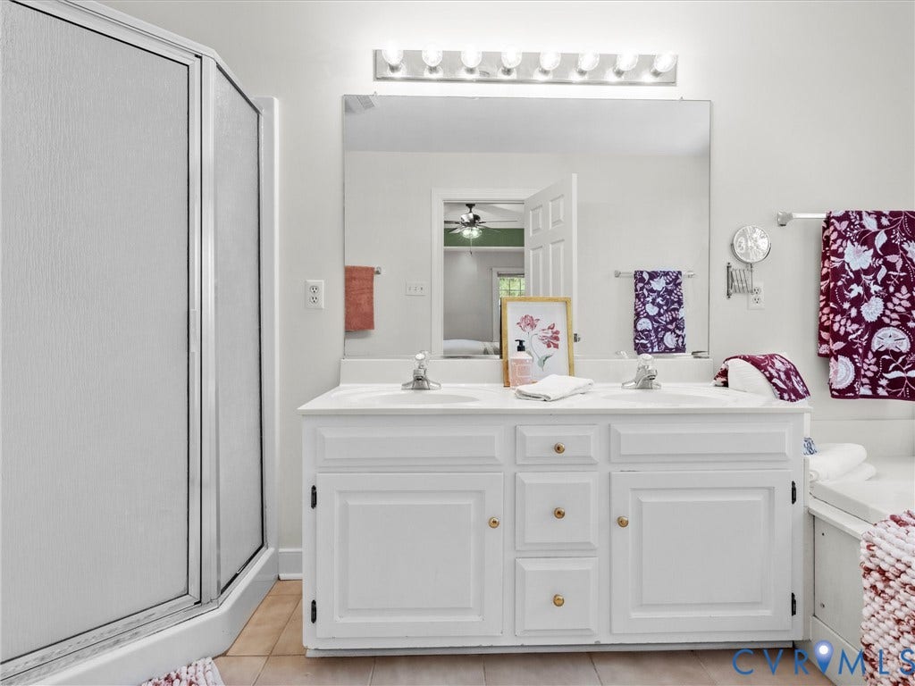 12000 Glen Kilchurn Drive, Chesterfield, VA 23838 Dual vanity with white cabinetry and integrated sinks, a large mirror, overhead vanity lighting, and a walk-in shower with frosted glass enclosure