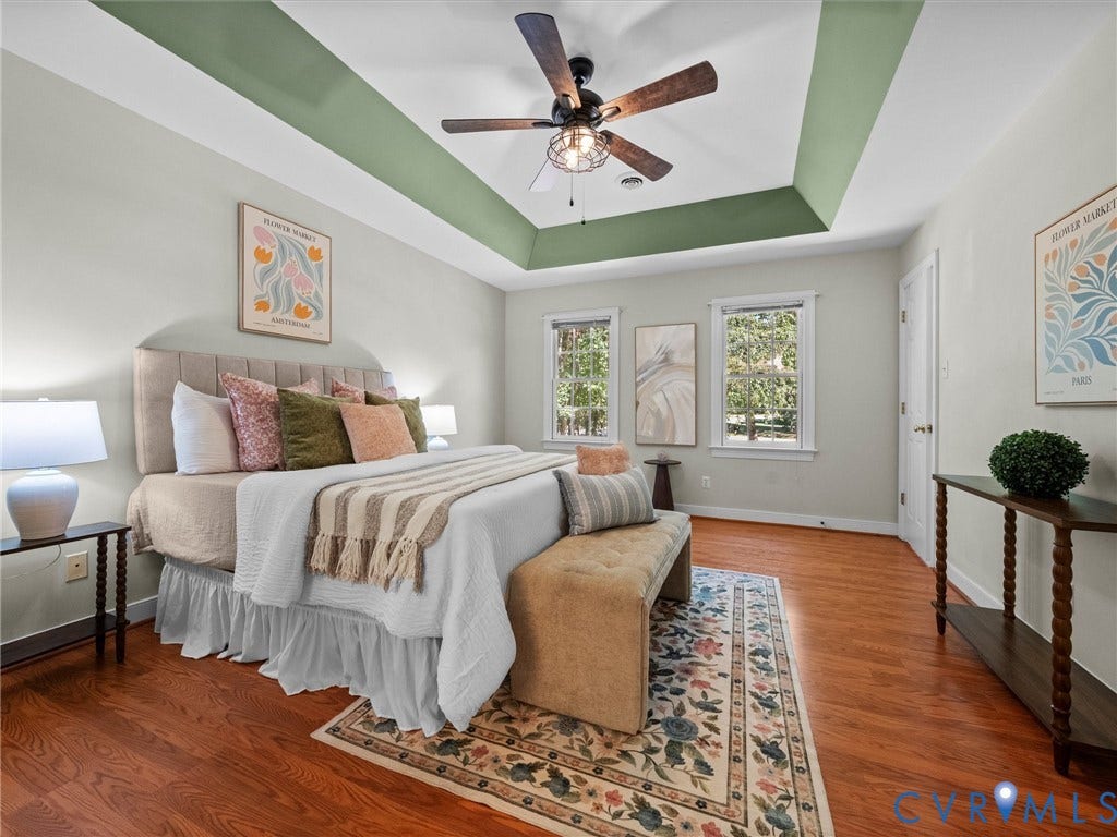 12000 Glen Kilchurn Drive, Chesterfield, VA 23838 Tray ceiling with accent paint, wood-finish flooring, two windows providing natural light, ceiling fan with light fixture, and a solid white door