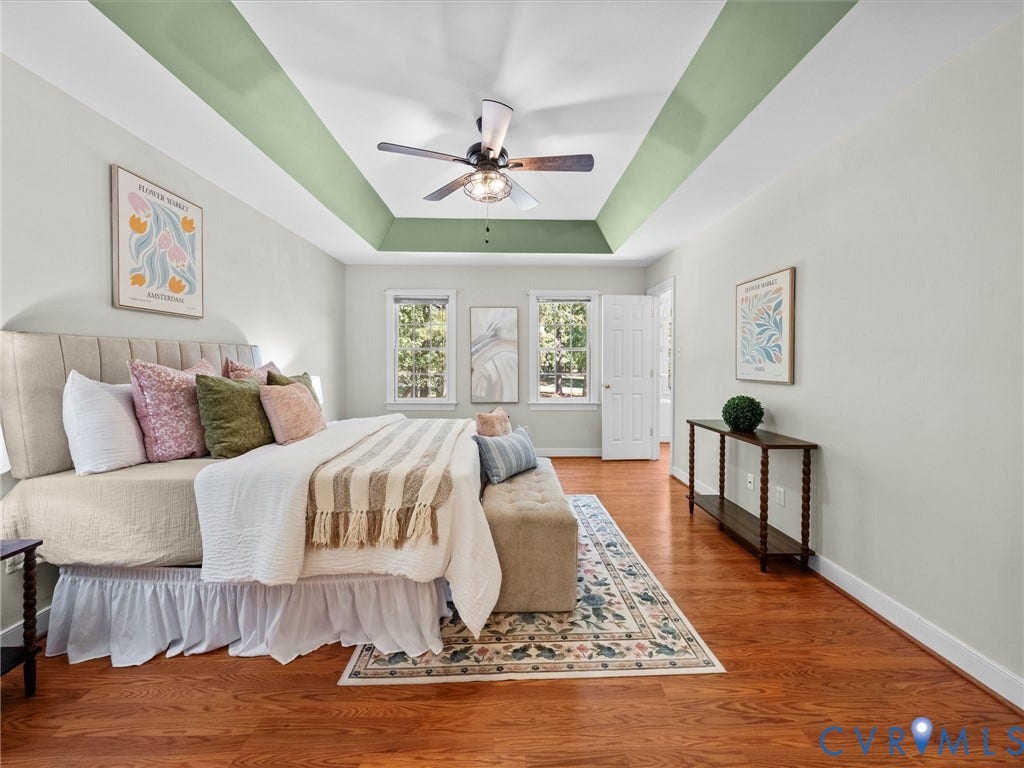12000 Glen Kilchurn Drive, Chesterfield, VA 23838 Tray ceiling with decorative paint accent, ceiling fan with integrated lighting, wood-finish flooring, white paneled interior door, and multiple windows