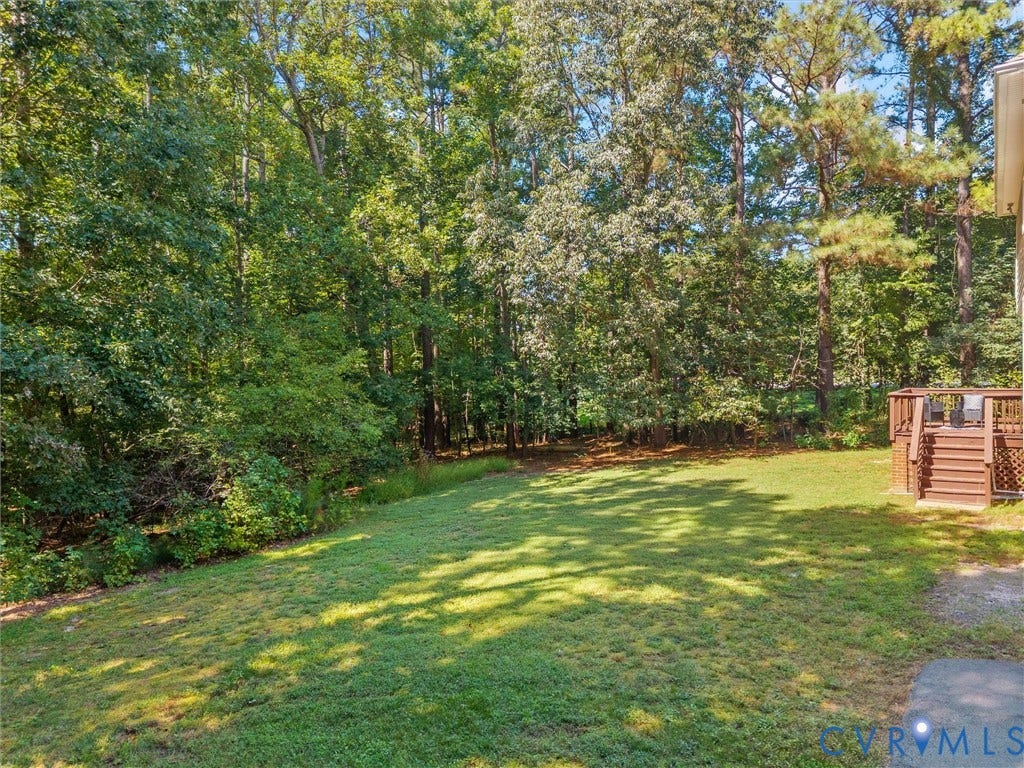 12000 Glen Kilchurn Drive, Chesterfield, VA 23838 Expansive backyard with a manicured lawn, established trees, and a multi-level wood deck