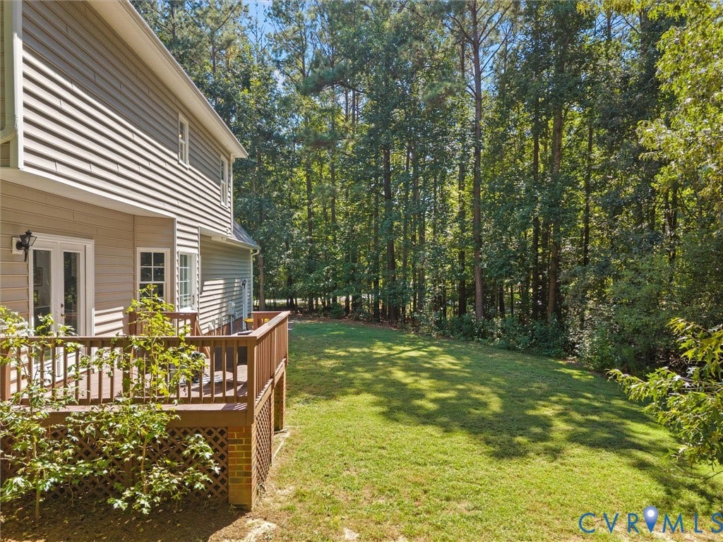 12000 Glen Kilchurn Drive, Chesterfield, VA 23838 Spacious backyard with a wooden deck, mature trees, and a manicured lawn