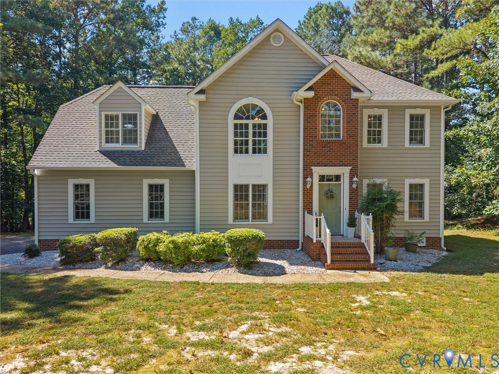 12000 Glen Kilchurn Drive, Chesterfield, VA 23838 Two-story residence featuring light-colored siding, brick accents, white trim, and a prominent arched window above the entry