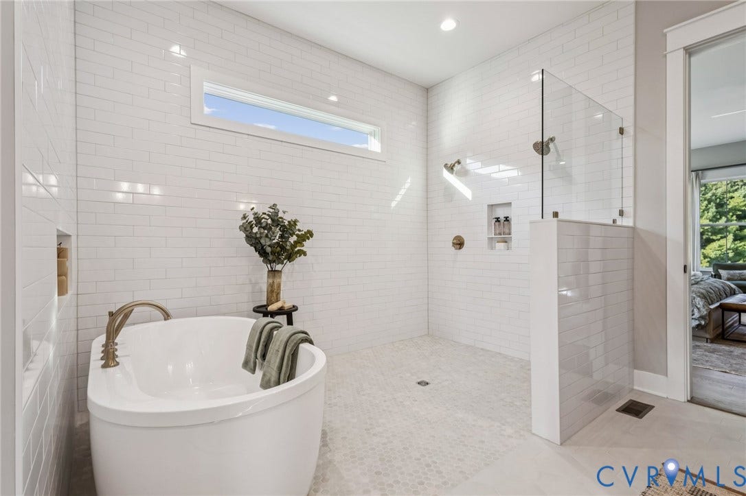 Lot 5 Olivet Church Road, Olivet Church Estates, New Kent, VA 23124 Freestanding soaking tub with brass-toned fixtures, walk-in shower with glass enclosure, white subway tile walls, and a horizontal transom window