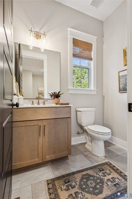 Lot 5 Olivet Church Road, Olivet Church Estates, New Kent, VA 23124 Elegant primary bathroom featuring a wood-finish vanity with dual-sink configuration, polished brass hardware, and a framed mirror with integrated lighting