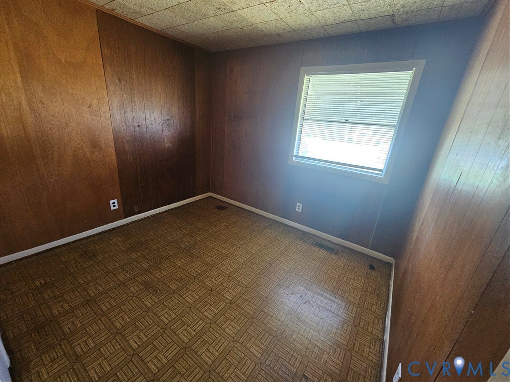 1210 W Leigh Street, Richmond, VA 23220 Wood-paneled walls and a window with horizontal blinds