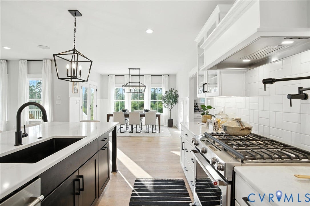 Lot 1 Needlewood Court, Olivet Church Estates, New Kent, VA 23124 Bright kitchen featuring a waterfall island with a black sink, a gas range with a pot filler, and white cabinetry