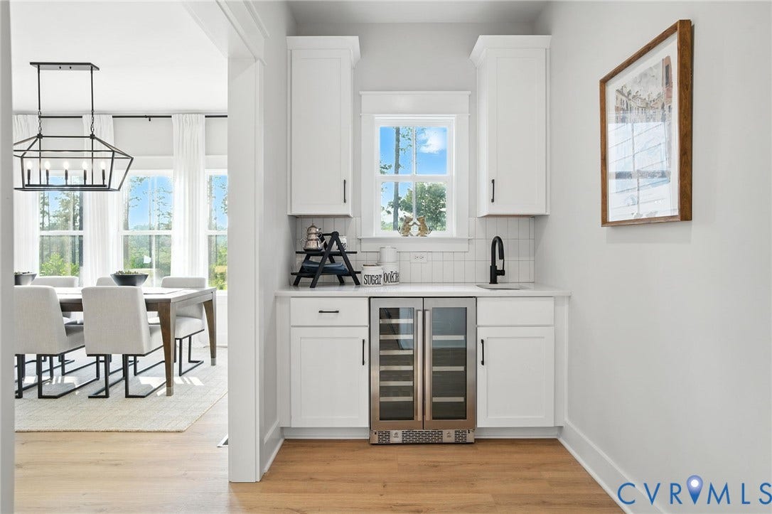 Lot 1 Needlewood Court, Olivet Church Estates, New Kent, VA 23124 Built-in beverage station featuring white cabinetry, a counter-depth dual-zone wine and beverage cooler, and a matte black faucet