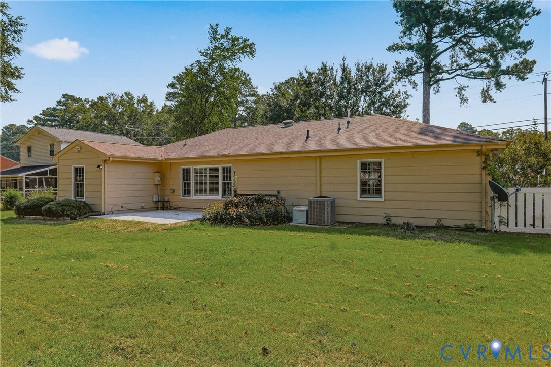 4810 Conduit Road, Colonial Heights, VA 23834 Expansive backyard featuring a concrete patio, mature landscaping, and a privacy fence