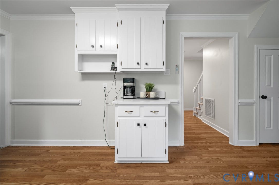 4525 Old Mesa Drive, North Chesterfield, VA 23237 White cabinetry with black hardware, wood-finish flooring, white crown molding, and white door with black hardware