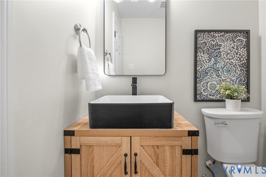 4525 Old Mesa Drive, North Chesterfield, VA 23237 Wood-finish vanity with a rectangular vessel sink, matte black faucet, and a wall-mounted rectangular mirror