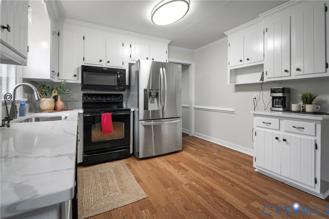 4525 Old Mesa Drive, North Chesterfield, VA 23237 Kitchen featuring wood-finish flooring, white cabinetry, a stainless steel refrigerator, black range, and white countertops with a sink