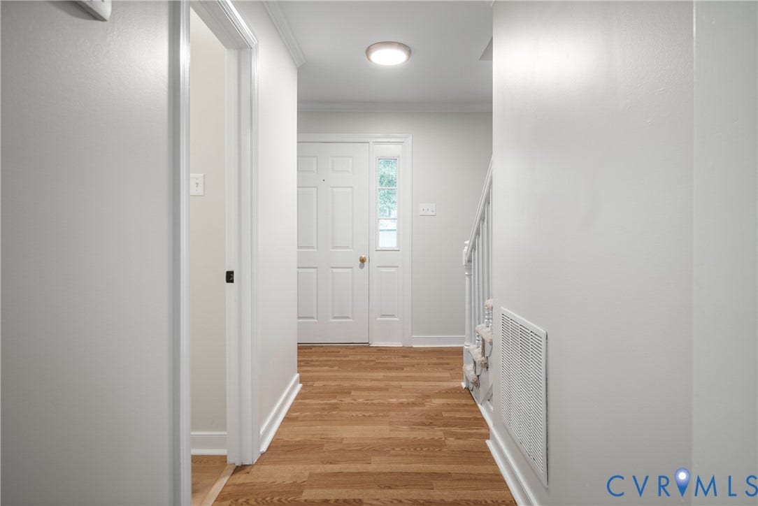 4525 Old Mesa Drive, North Chesterfield, VA 23237 Wood-finish flooring, white paneled entry door with sidelight, crown molding, and a flush mount ceiling fixture