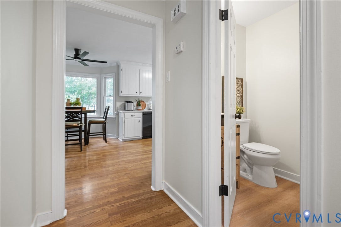 4525 Old Mesa Drive, North Chesterfield, VA 23237 Hardwood flooring throughout, white cabinetry with dark hardware, bay window with multiple panes, black ceiling fan, and a white toilet