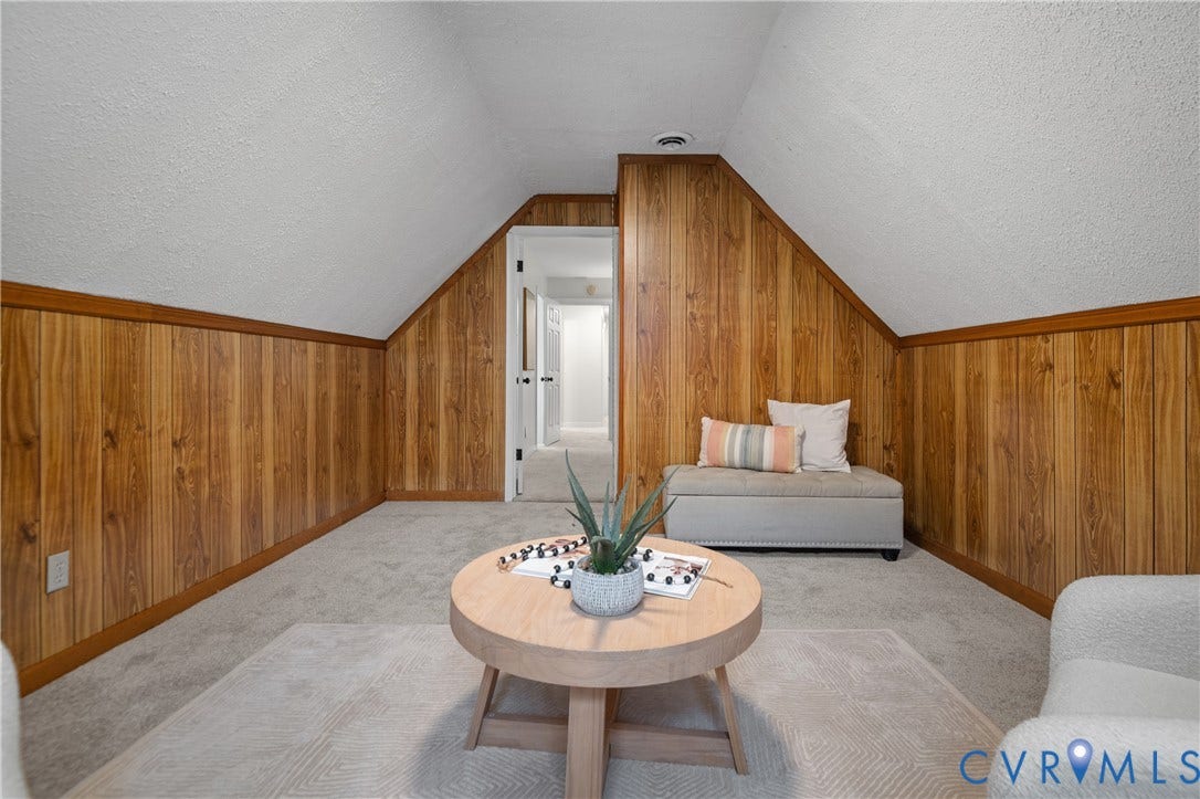 4525 Old Mesa Drive, North Chesterfield, VA 23237 Sloped ceiling room featuring wood paneling, wood trim, and light-colored carpet flooring