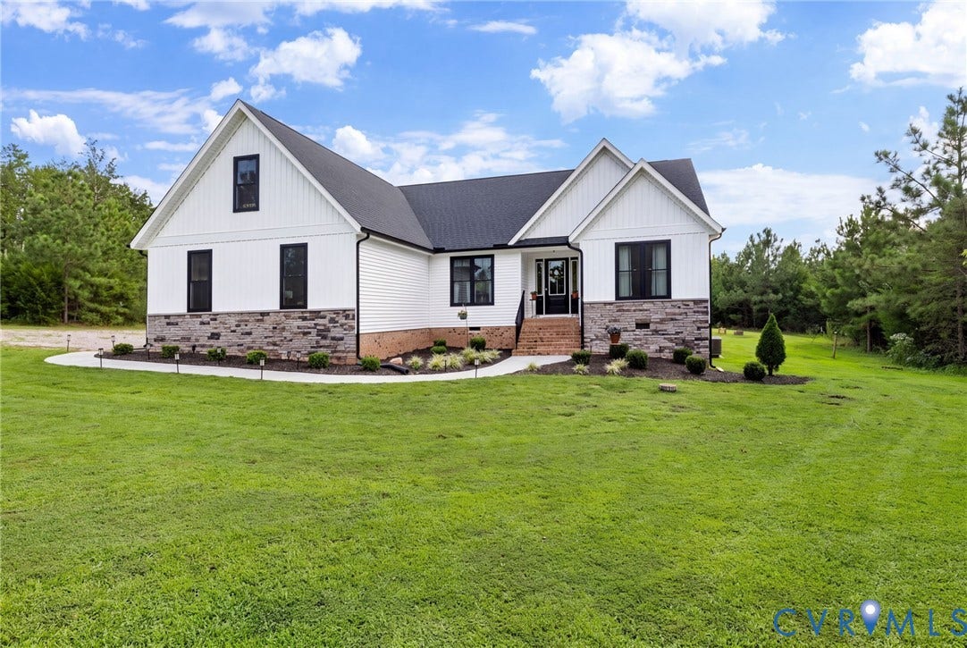 2927 Poorhouse Road, 522 Corridor, Goochland, VA 23063 White siding exterior with black window frames, stone facade accents, dark shingle roof, and a concrete walkway with integrated lighting