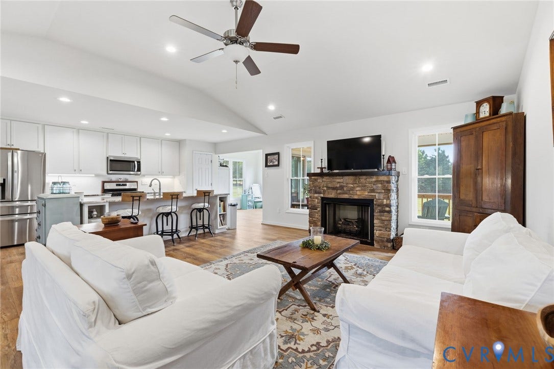 2927 Poorhouse Road, 522 Corridor, Goochland, VA 23063 Vaulted ceiling with a ceiling fan, recessed lighting, LVP flooring, stone-clad fireplace, and white kitchen cabinetry