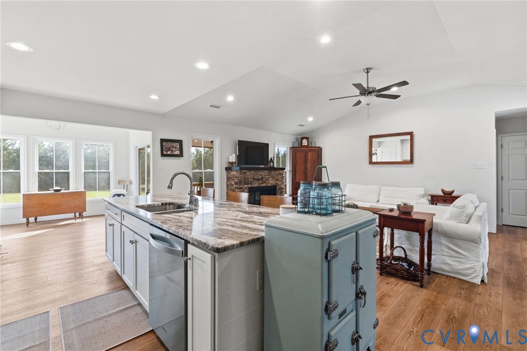 2927 Poorhouse Road, 522 Corridor, Goochland, VA 23063 Open-concept living area featuring a kitchen island with stone countertop, stainless steel appliances, LVP flooring, a vaulted ceiling, and recessed lighting