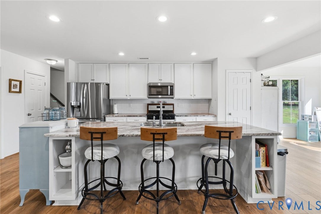 2927 Poorhouse Road, 522 Corridor, Goochland, VA 23063 Kitchen island with built-in storage, stainless steel appliances, white cabinetry, integrated sink, and LVP flooring