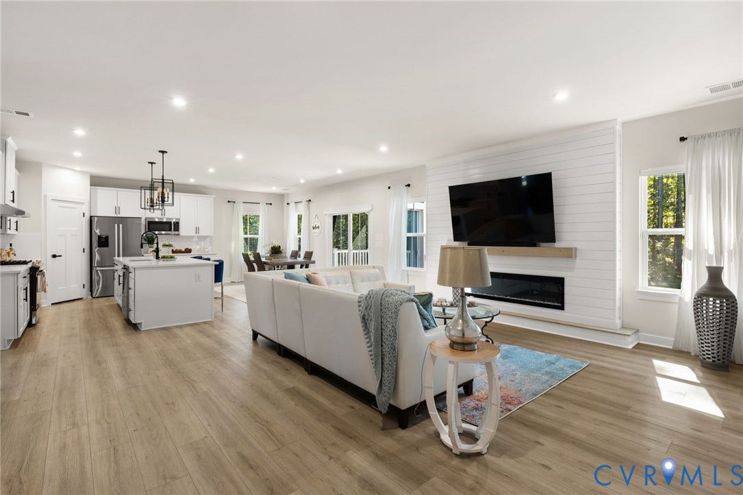 8618 McKibben Drive, The Highlands, Chesterfield, VA 23838 Open-concept living area with wood-finish flooring, recessed lighting, and a shiplap accent wall with a built-in electric fireplace