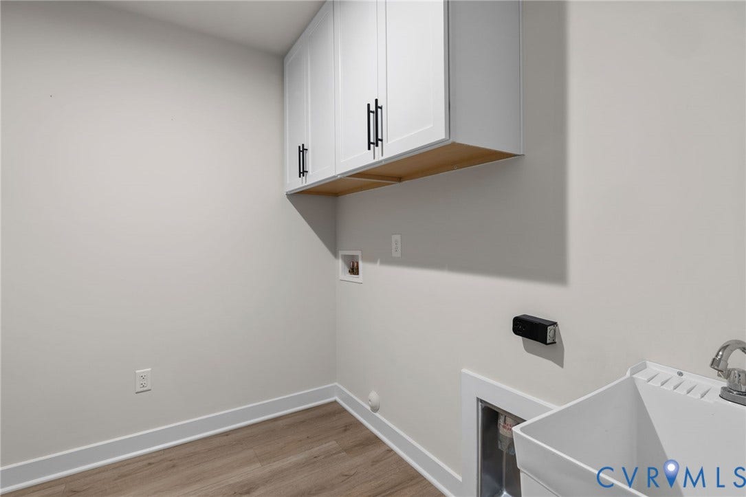 8618 McKibben Drive, The Highlands, Chesterfield, VA 23838 White wall-mounted cabinetry with matte black hardware, utility sink with chrome faucet, and wood-finish flooring