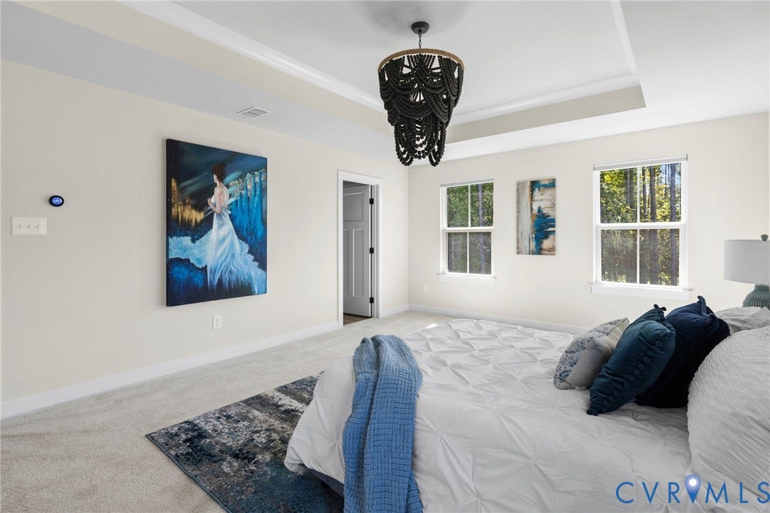 8618 McKibben Drive, The Highlands, Chesterfield, VA 23838 Tray ceiling with a decorative chandelier, two double-hung windows, light-toned carpeting, and a paneled interior door