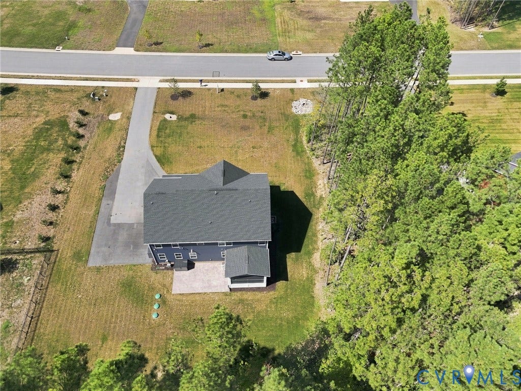 8618 McKibben Drive, The Highlands, Chesterfield, VA 23838 Dark gray roof, light blue siding, paved driveway, stone patio, and surrounding trees