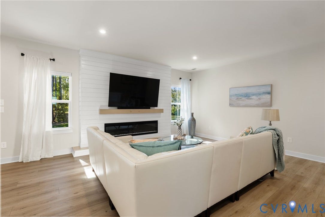 8618 McKibben Drive, The Highlands, Chesterfield, VA 23838 Wood-finish flooring throughout, recessed lighting, and a shiplap accent wall with a built-in electric fireplace and wood mantel