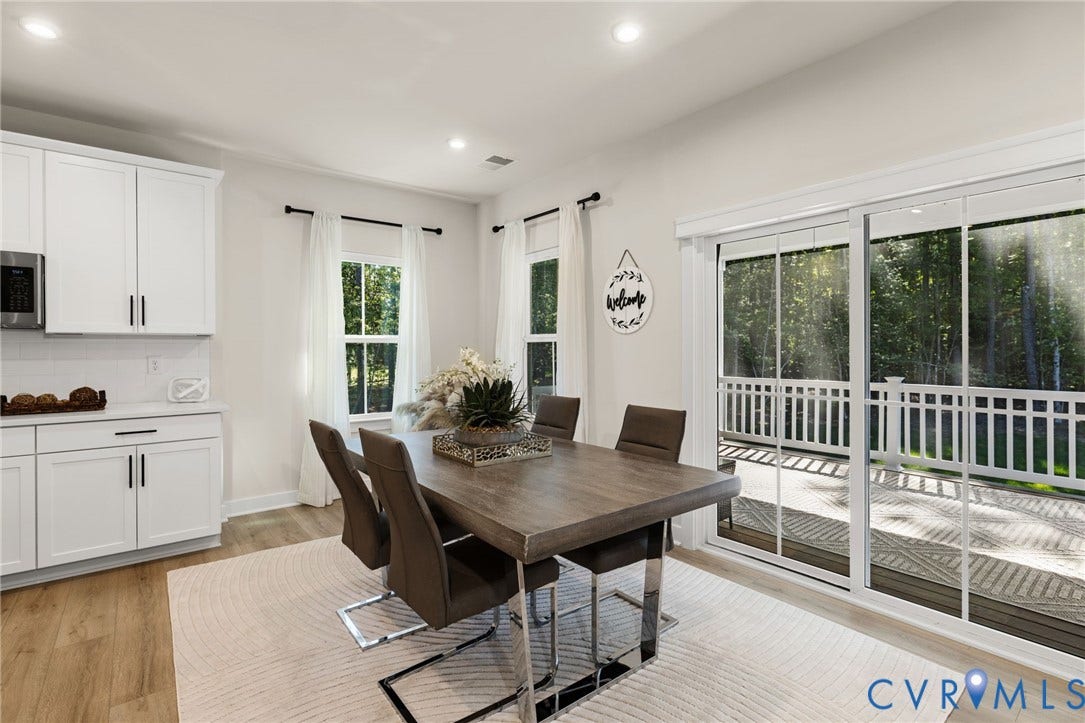 8618 McKibben Drive, The Highlands, Chesterfield, VA 23838 White cabinetry with black hardware, wood-finish flooring, recessed lighting, and a sliding glass door to an outdoor deck