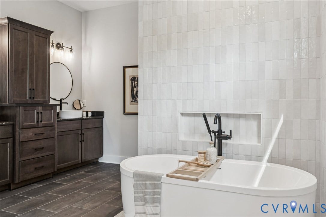 Lot 2 Needlewood Court, Olivet Church Estates, New Kent, VA 23124 Freestanding soaking tub with a wall-mounted faucet, dark wood-finish cabinetry, tile flooring, and a tiled accent wall with an integrated niche