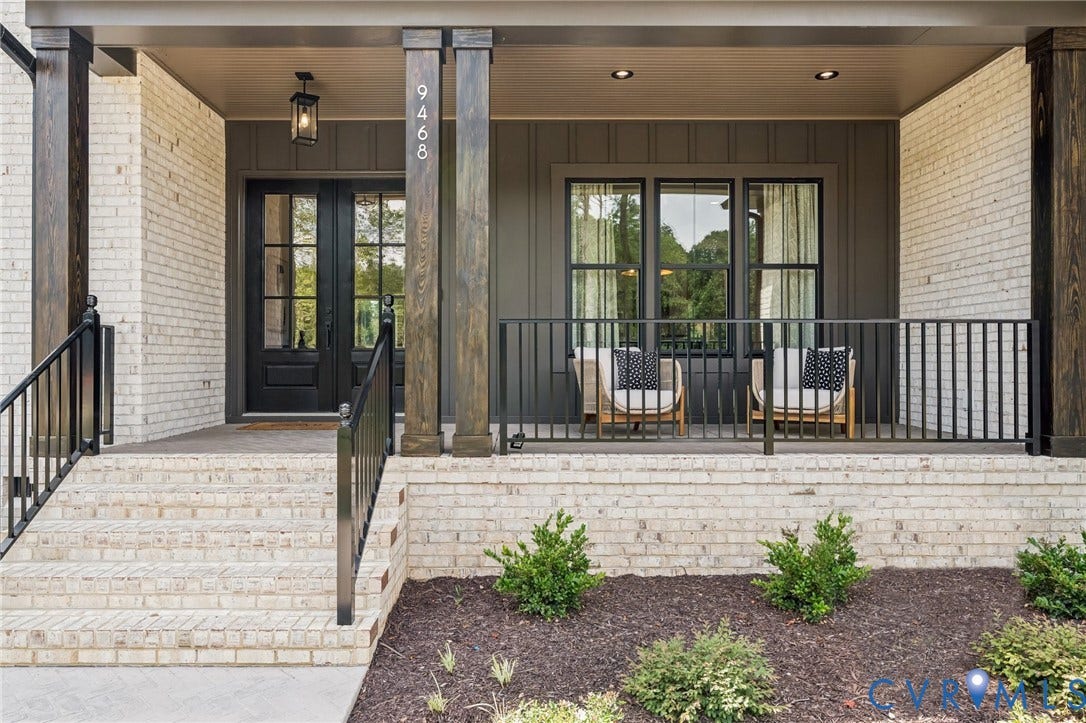Lot 2 Needlewood Court, Olivet Church Estates, New Kent, VA 23124 Covered front porch featuring white brick siding, wood-wrapped columns, a dark panel door, and dark framed windows