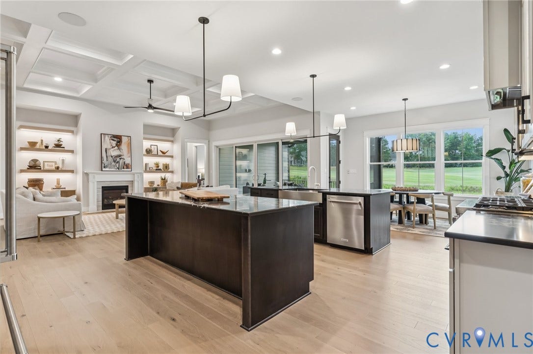 Lot 2 Needlewood Court, Olivet Church Estates, New Kent, VA 23124 Open-concept living area with light wood-finish flooring, coffered ceiling, a fireplace with a mantel, and built-in shelving with integrated lighting