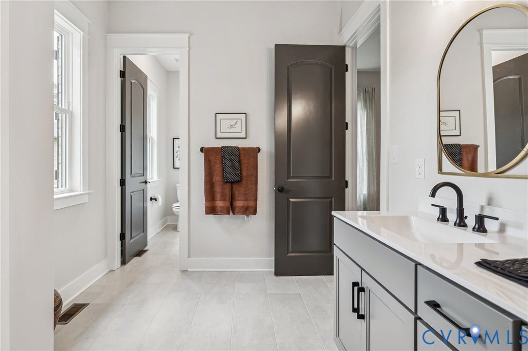 Lot 2 Needlewood Court, Olivet Church Estates, New Kent, VA 23124 Light-toned tile flooring, contemporary vanity with a white countertop and integrated sink, black fixtures, and a framed mirror