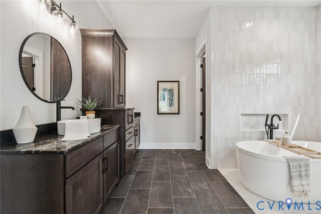 Lot 2 Needlewood Court, Olivet Church Estates, New Kent, VA 23124 Dark wood-finish vanity with stone countertop, round mirror, and wall-mounted light fixture