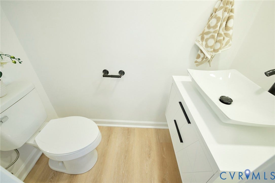 3103 Q St, Church Hill, Richmond, VA 23223 White vanity with matte black hardware, integrated vessel sink, and wood-finish flooring