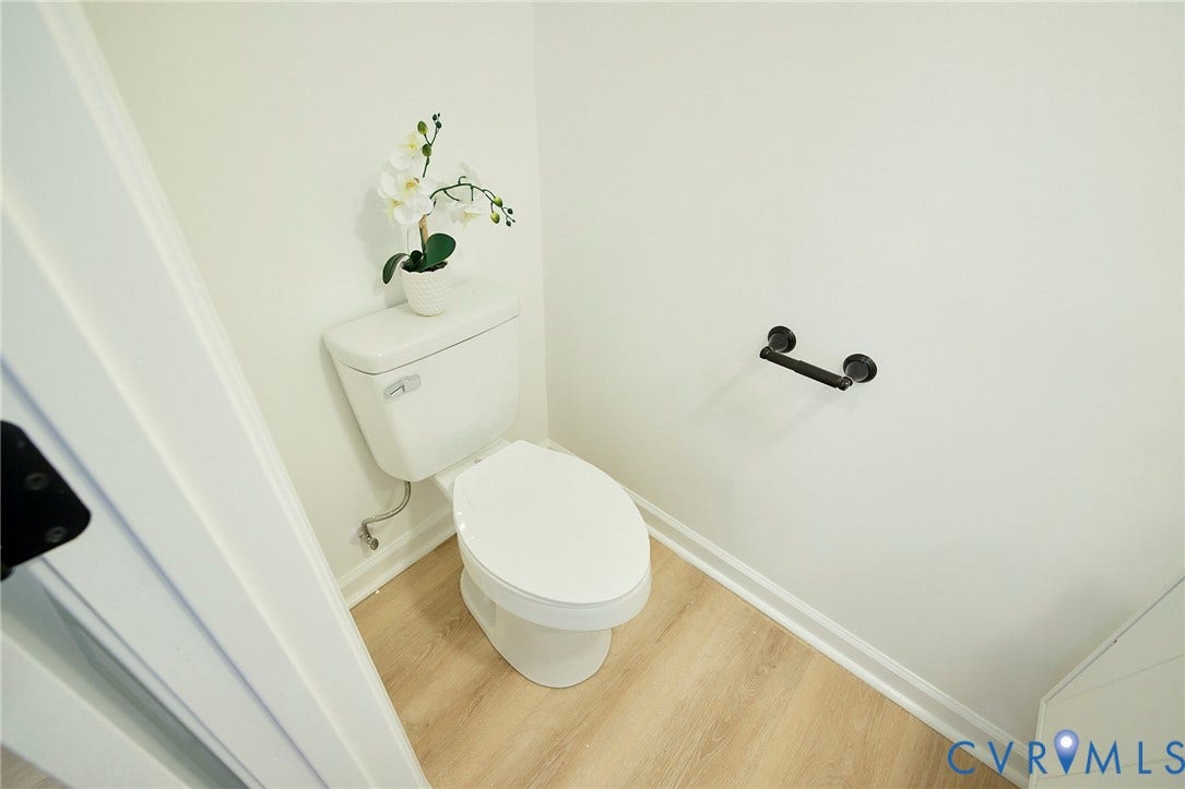 3103 Q St, Church Hill, Richmond, VA 23223 White toilet with light wood-finish flooring and matte black hardware