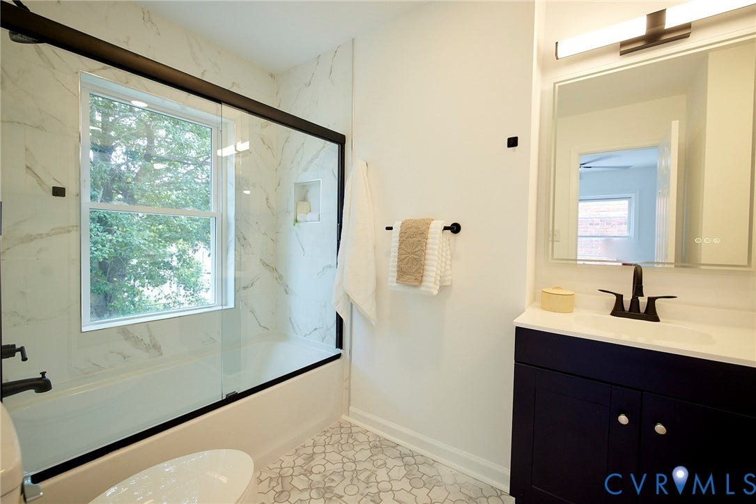 3103 Q St, Church Hill, Richmond, VA 23223 Bathroom featuring a dark vanity with white countertop, black fixtures, and a lighted mirror