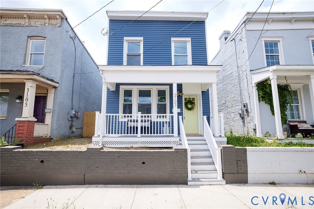 3103 Q St, Church Hill, Richmond, VA 23223 Blue facade with white trim, front porch with white railing, light yellow front door, and a multi-level concrete and brick retaining wall