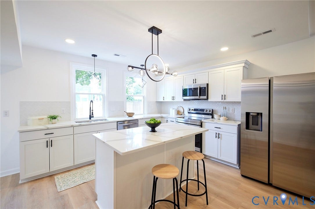 3103 Q St, Church Hill, Richmond, VA 23223 White shaker-style cabinetry with matte black hardware, stainless steel appliances, a center island with a quartz countertop, and wood-finish flooring