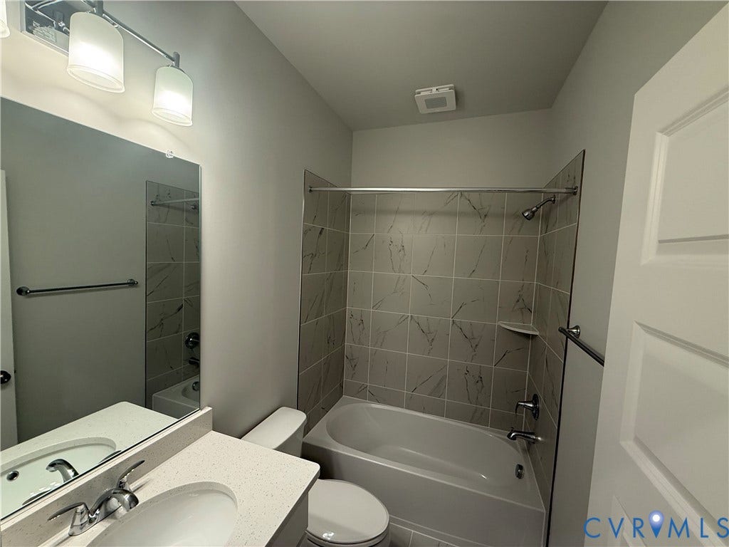 9452 belladdie Way, Glen Allen, VA 23059 Full bathroom featuring a rectangular vanity mirror, dual-light fixture, tub/shower combination with tile surround, and a built-in shower shelf