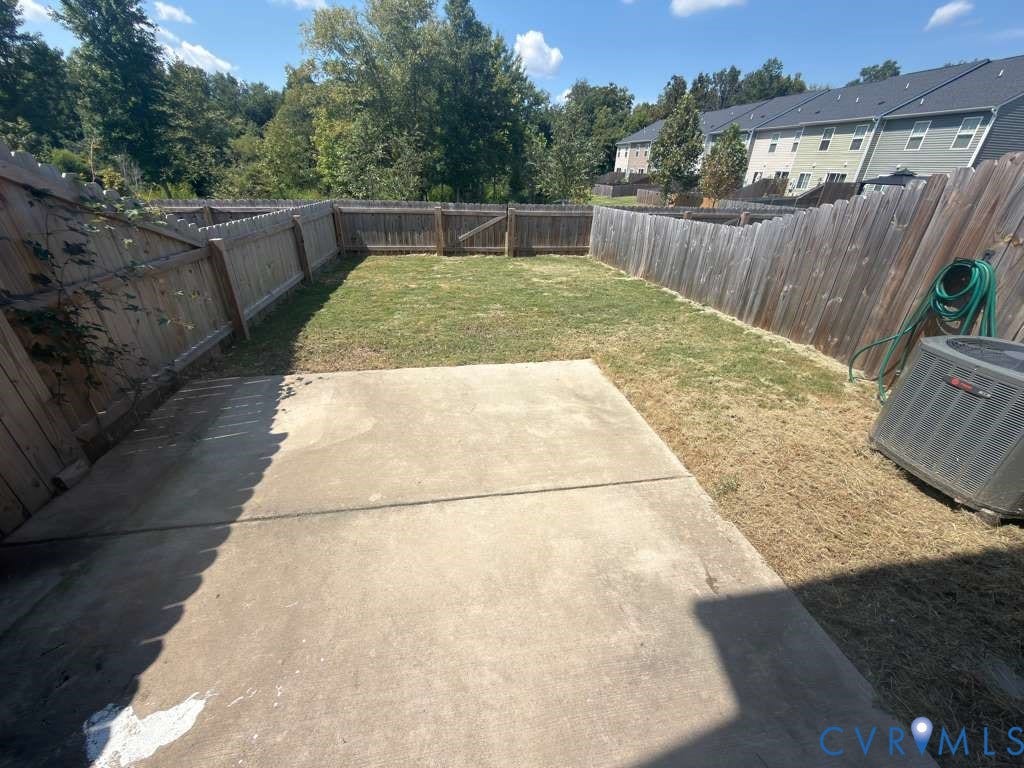 Private fenced yard featuring a concrete patio and a wooden privacy fence