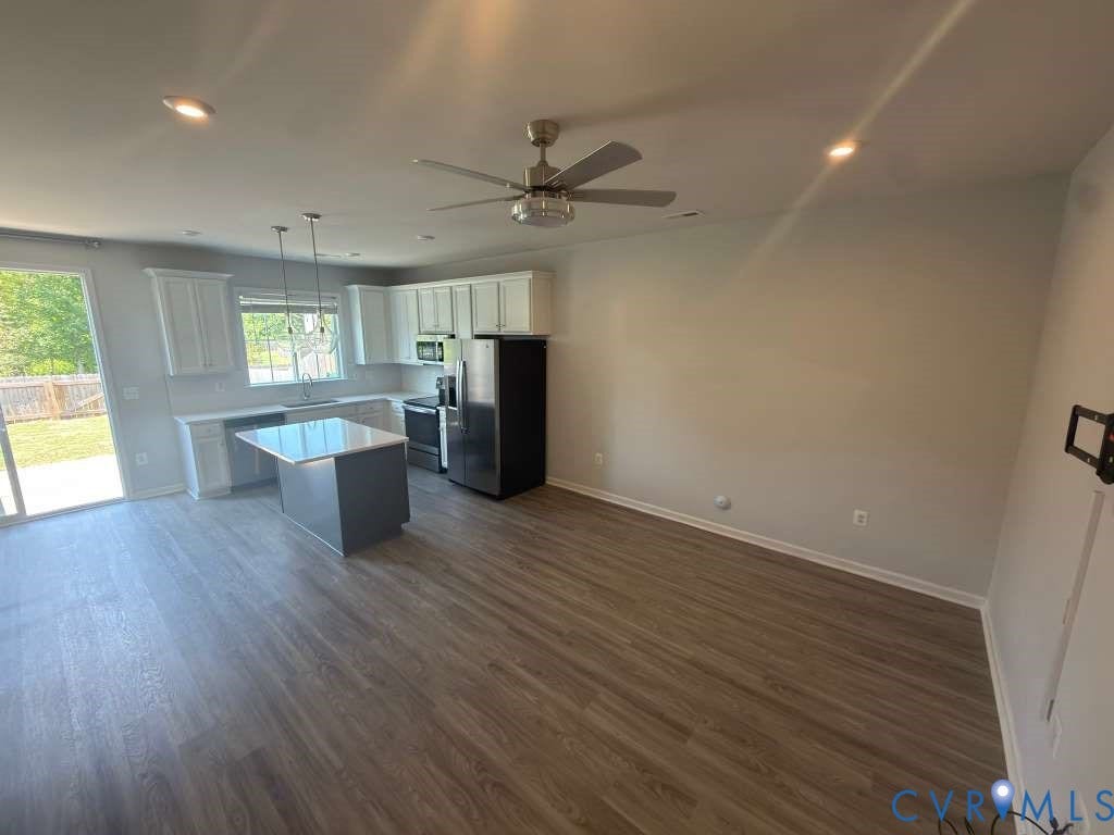 Modern kitchen with white cabinetry, stainless steel appliances, and a central island