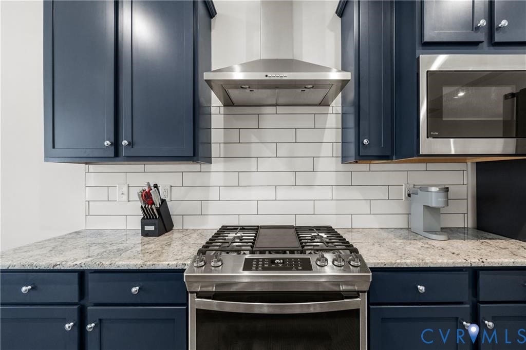 12221 Dutch Elm Circle, Midlothian, VA 23112 Stainless steel range with a coordinating vent hood, white subway tile backsplash, blue shaker-style cabinetry, and light-toned countertops