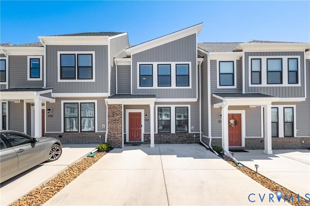 12221 Dutch Elm Circle, Midlothian, VA 23112 Contemporary townhome exterior featuring gray siding, white trim, red entry doors, and covered entrances