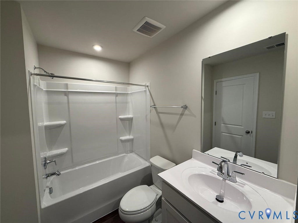 5409 Canterbury Ridge Way, Richmond, VA 23224 Integrated tub and shower combination, chrome fixtures, single vanity with integrated sink, wood-finish flooring, and wall-mounted mirror