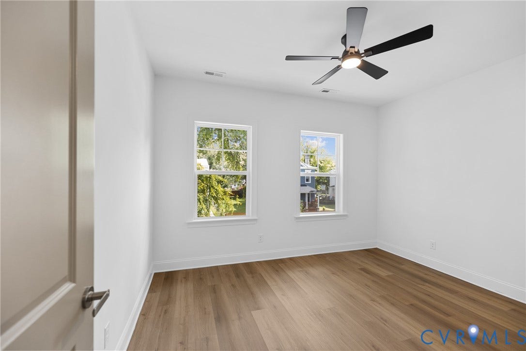 Wood-finish flooring, white walls, and a contemporary ceiling fan with integrated lighting