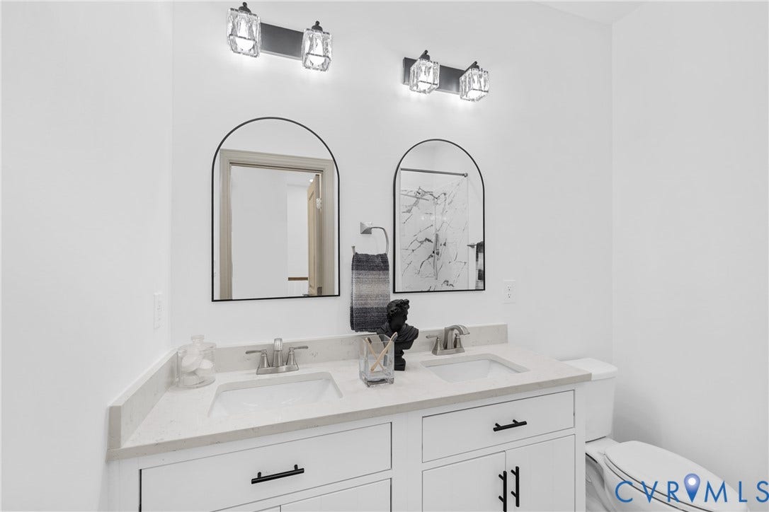 Dual vanity with white cabinetry and black hardware