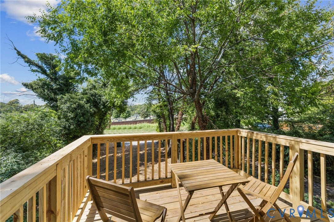 Primary bedroom private deck with a full wood railing and natural surroundings
