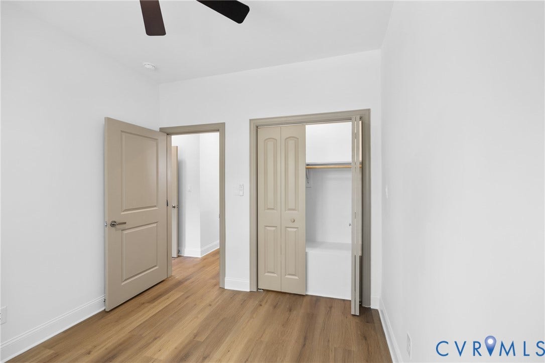 Wood-finish flooring, white walls, and a ceiling fan